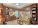 Cozy home office featuring custom built-ins, desk, and a comfortable seating area at 4761 Pine Harrier Dr, Sarasota, FL 34231