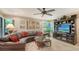 Inviting living room with leather sectional, entertainment center, and scenic views from bay windows at 4761 Pine Harrier Dr, Sarasota, FL 34231