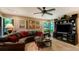 Inviting living room featuring a large leather sectional, ceiling fan, and a beautiful display of wall art at 4761 Pine Harrier Dr, Sarasota, FL 34231