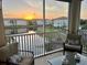 Screened balcony view of a community lake at sunset with outdoor seating at 500 San Lino Cir # 534, Venice, FL 34292