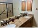 Spacious bathroom with double sinks, granite counters, walk-in shower, and framed mirrors at 500 San Lino Cir # 534, Venice, FL 34292