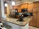 Bright kitchen features granite counters, stainless steel appliances, and wood cabinetry at 500 San Lino Cir # 534, Venice, FL 34292