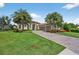Beautiful home featuring manicured lawn, stone driveway, tropical landscaping, and a neutral color scheme at 5104 Benito Ct, Bradenton, FL 34211