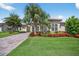 Charming home featuring a well-manicured lawn, a brick driveway, and colorful flower beds enhancing its curb appeal at 5104 Benito Ct, Bradenton, FL 34211