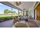 Screened in lanai with wicker furniture provides views of the verdant golf course at 5104 Benito Ct, Bradenton, FL 34211