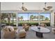 Screened lanai with ceiling fans and comfortable seating offers relaxing views of lush landscaping and golf course at 5104 Benito Ct, Bradenton, FL 34211