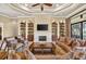 Elegant living room with coffered ceiling, fireplace, built-in shelves, and plush seating at 5104 Benito Ct, Bradenton, FL 34211