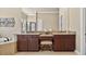 Elegant bathroom featuring granite countertops, wood cabinets, and large mirrors at 5104 Benito Ct, Bradenton, FL 34211