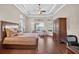 Large primary bedroom featuring tray ceiling, sitting area, and hardwood floors at 5104 Benito Ct, Bradenton, FL 34211