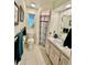 Cozy bathroom with neutral tile, white fixtures, and a shower with patterned curtain at 5350 Barbarossa Ave, Sarasota, FL 34235