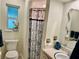 Cozy bathroom features a toilet, shower with floral curtain, and large window at 5350 Barbarossa Ave, Sarasota, FL 34235