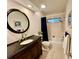 Elegant bathroom boasts a stylish vanity, tub/shower combination, and a framed round mirror at 5350 Barbarossa Ave, Sarasota, FL 34235