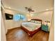 Bedroom featuring wood flooring, a ceiling fan and a mounted TV at 5350 Barbarossa Ave, Sarasota, FL 34235