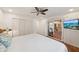 Light-filled bedroom featuring a ceiling fan, closet, TV, and sliding glass door at 5350 Barbarossa Ave, Sarasota, FL 34235