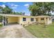 Charming single-story home with yellow siding, white shutters, and a well-manicured lawn and landscaping at 5350 Barbarossa Ave, Sarasota, FL 34235