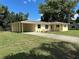 Charming yellow home with a well-manicured lawn, carport, and classic shutters at 5350 Barbarossa Ave, Sarasota, FL 34235