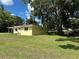 Exterior side view of yellow home highlighting the well-manicured lawn and mature trees at 5350 Barbarossa Ave, Sarasota, FL 34235