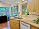 Galley kitchen featuring tile floors, stainless steel sink, and modern appliances offering backyard view at 5350 Barbarossa Ave, Sarasota, FL 34235