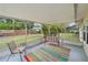 Relaxing screened porch with a colorful striped rug, chair, and swing, offering a tranquil outdoor space at 5350 Barbarossa Ave, Sarasota, FL 34235