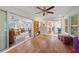 Bright sunroom featuring wood floors, sliding glass doors and views into kitchen and living room at 5350 Barbarossa Ave, Sarasota, FL 34235