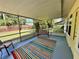Bright sunroom with a colorful rug, a swing and view of the backyard at 5350 Barbarossa Ave, Sarasota, FL 34235