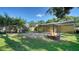 Spacious backyard featuring a fire pit, playground set, and covered patio at 5438 Potter St, Sarasota, FL 34232