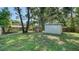 Lush backyard featuring a storage shed, laundry, wooden fence, and swing set at 5438 Potter St, Sarasota, FL 34232