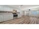 Well-lit kitchen with stainless steel appliances, white cabinetry, mosaic backsplash, and wood-look flooring at 5438 Potter St, Sarasota, FL 34232