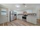 Modern kitchen featuring stainless steel appliances, white cabinets, and wood-look flooring with ample natural light at 5438 Potter St, Sarasota, FL 34232