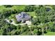 Aerial shot of a private estate surrounded by trees featuring a screened pool, and lush landscaping at 6050 Saddle Oak Trl, Sarasota, FL 34241