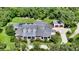 Expansive estate aerial view highlighting the home, lush landscaping, circular driveway, and additional garage at 6050 Saddle Oak Trl, Sarasota, FL 34241