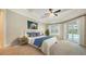 Bright bedroom with a tray ceiling, ceiling fan, and sliding glass doors that provide access to the pool area at 6050 Saddle Oak Trl, Sarasota, FL 34241