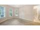 Light-filled bedroom with neutral carpet, white trim, and large windows at 6050 Saddle Oak Trl, Sarasota, FL 34241