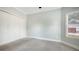 Clean and carpeted bedroom with neutral walls, a window, and closet space at 6050 Saddle Oak Trl, Sarasota, FL 34241