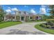 Attractive home with verdant lawn, stone accents, columns, mature trees, and winding driveway at 6050 Saddle Oak Trl, Sarasota, FL 34241