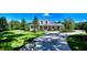 Elegant home with lush green lawn, circular driveway, and covered front porch exuding timeless charm at 6050 Saddle Oak Trl, Sarasota, FL 34241