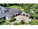 Aerial view of the home featuring a long driveway, three car garage, and mature trees at 6050 Saddle Oak Trl, Sarasota, FL 34241
