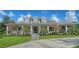 Inviting front exterior with stone accents, a manicured lawn, and a picturesque walkway to the entrance at 6050 Saddle Oak Trl, Sarasota, FL 34241