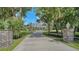 Long driveway lined with trees leads to this gorgeous home with dormer windows and flowering shrubs at 6050 Saddle Oak Trl, Sarasota, FL 34241