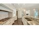 Bright, white kitchen featuring a large island with marble countertops, custom cabinetry, and stainless steel appliances at 6050 Saddle Oak Trl, Sarasota, FL 34241