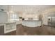 Bright, white kitchen featuring a large island with marble countertops, custom cabinetry, and stainless steel appliances at 6050 Saddle Oak Trl, Sarasota, FL 34241