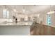 Bright, white kitchen featuring a large island with marble countertops, custom cabinetry, and stainless steel appliances at 6050 Saddle Oak Trl, Sarasota, FL 34241