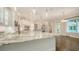Bright, white kitchen featuring a large island with marble countertops, custom cabinetry, and stainless steel appliances at 6050 Saddle Oak Trl, Sarasota, FL 34241