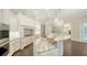 Bright, white kitchen featuring a large island with marble countertops, custom cabinetry, and stainless steel appliances at 6050 Saddle Oak Trl, Sarasota, FL 34241