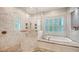 Bright main bathroom with a tub, a shower, and windows with white shutters at 6050 Saddle Oak Trl, Sarasota, FL 34241