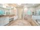 Bright main bathroom with a double sink vanity, a tub, and a glass enclosed walk-in shower at 6050 Saddle Oak Trl, Sarasota, FL 34241