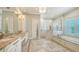 Bright main bathroom with a double sink vanity, a tub, and a glass enclosed walk-in shower at 6050 Saddle Oak Trl, Sarasota, FL 34241