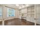 Bright office featuring custom cabinets, hardwood floors, and a large window at 6050 Saddle Oak Trl, Sarasota, FL 34241