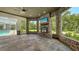 Outdoor stone patio featuring a fireplace, TV, and views of the garden at 6050 Saddle Oak Trl, Sarasota, FL 34241