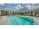 Gorgeous screened-in pool with stone deck and seamless connection to the home's interior at 6050 Saddle Oak Trl, Sarasota, FL 34241